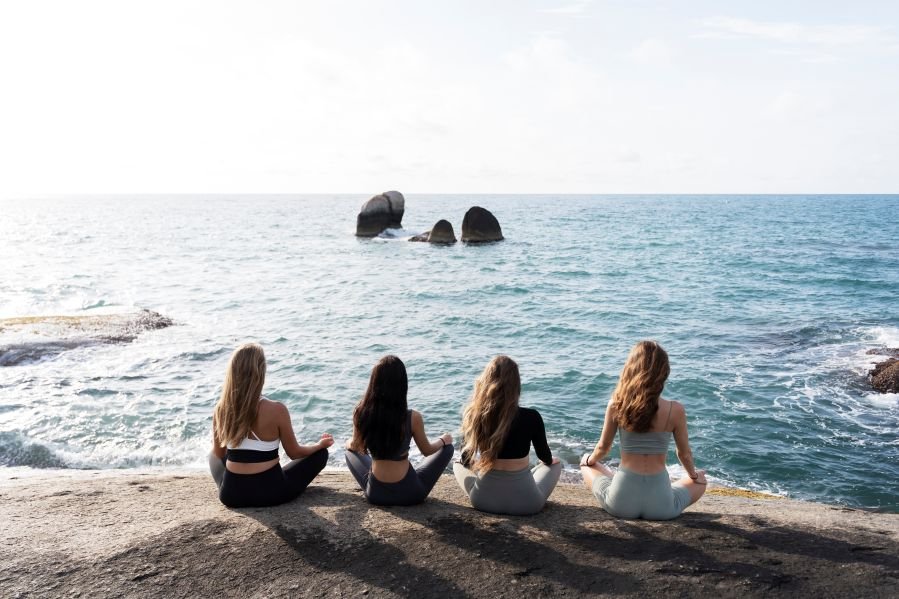full-shot-women-meditating-by-sea